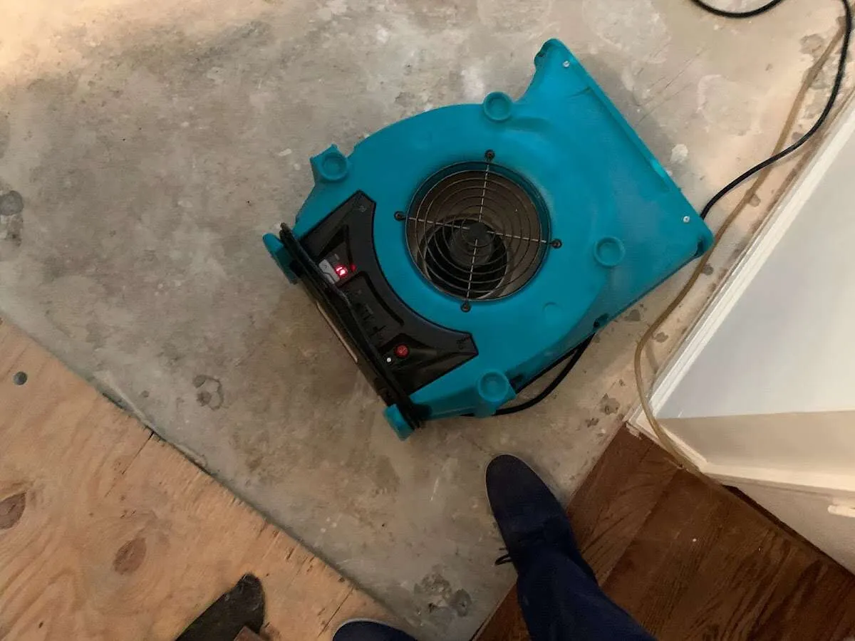 Air mover drying subfloor during Commercial Water Damage Restoration in Morrilton